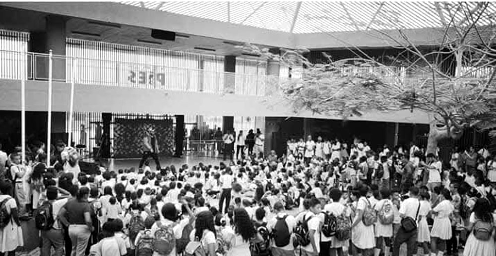 A school courtyard filled with children watching a performance at a Pies Descalzos school in Cartagena, Colombia